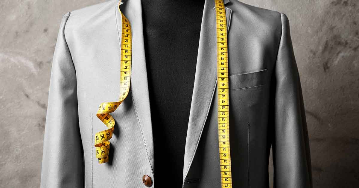 A mannequin wearing a suit with a measuring tape.